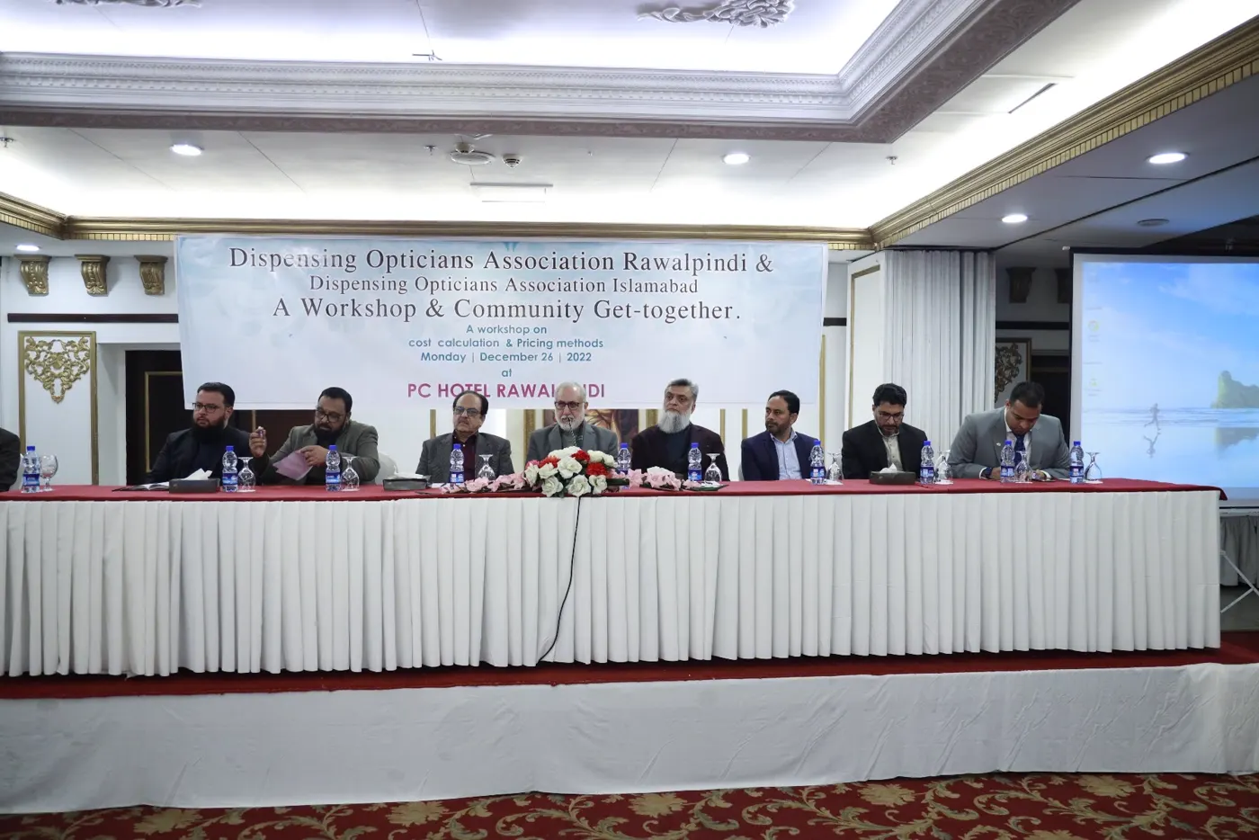 The Dispensing Opticians Association Rawalpindi and Islamabad panel seated under the workshop banner at PC Hotel Rawalpindi