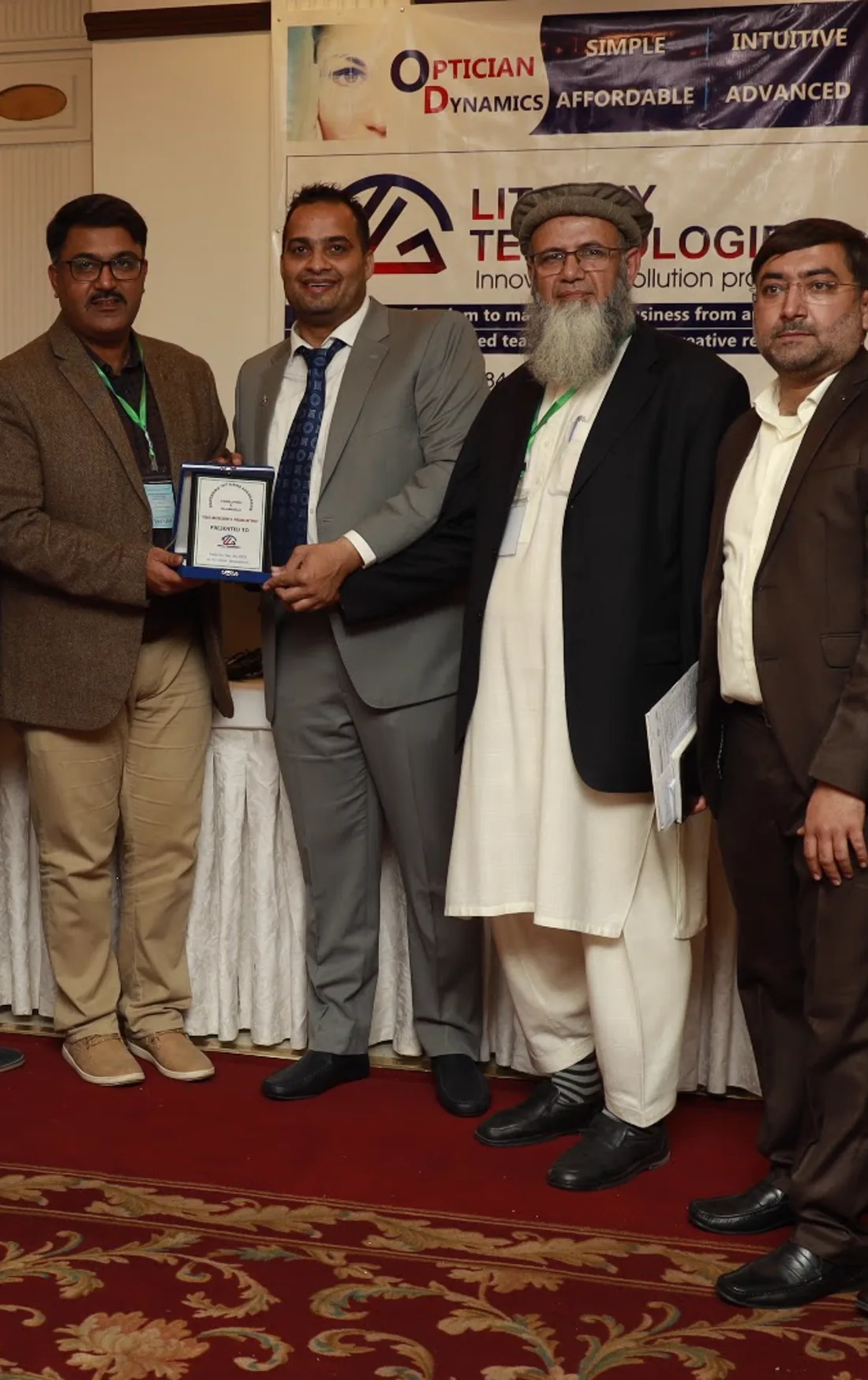 A Dispensing Opticians Association office-bearer handing the commemorative shield to LitGrey Technologies