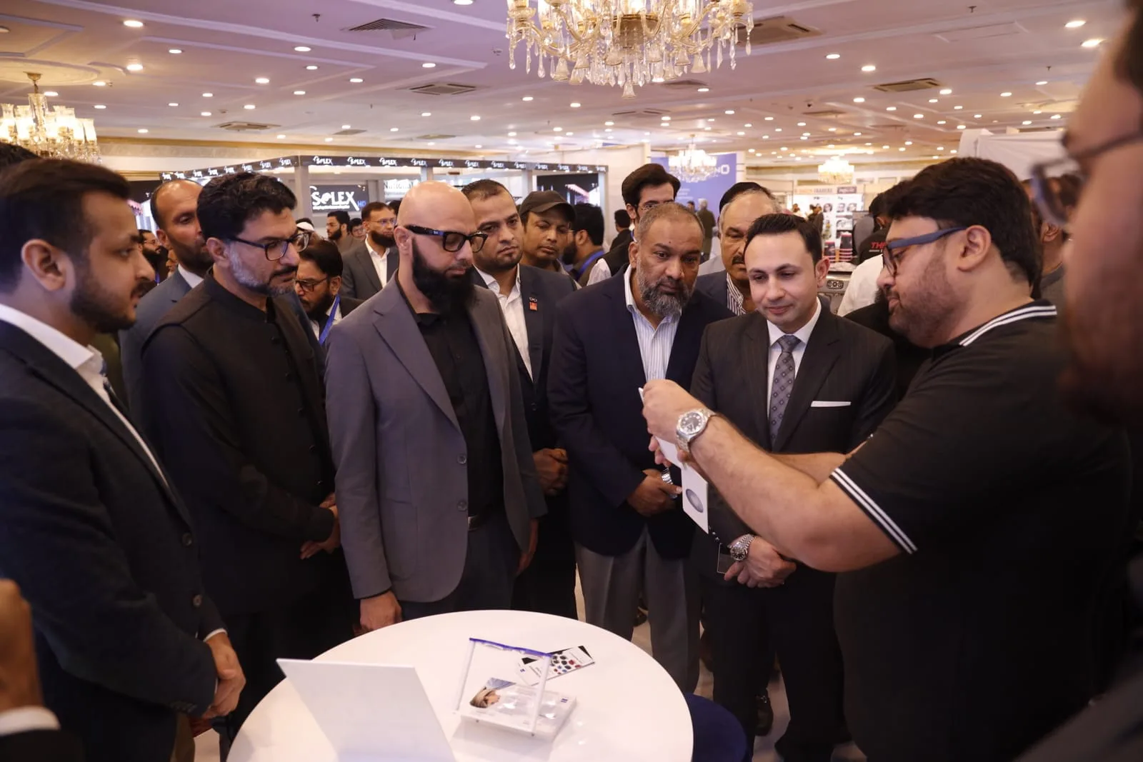A crowded demonstration table at OptiPak Expo 2025, Pearl Continental Hotel Rawalpindi